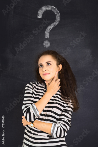 A shot of attractive young woman standing in front of blackboard