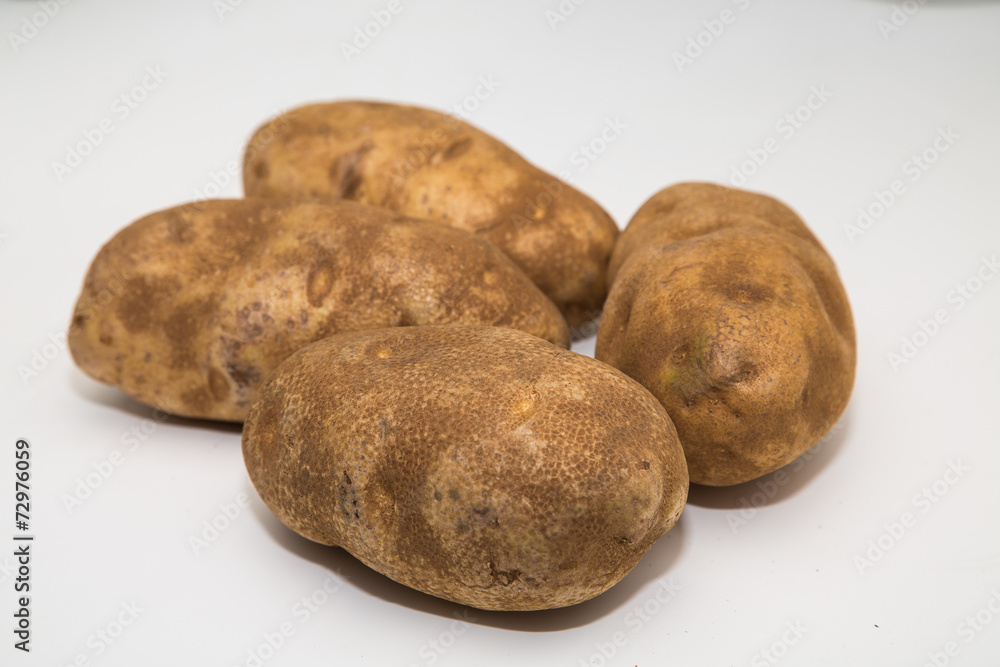 Fototapeta premium Four Potatoes on a White Counter