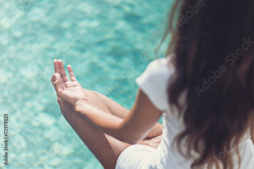 Slim Woman Meditating at the Poolside