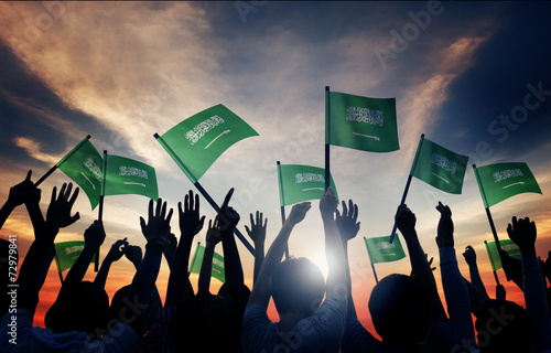 Silhouettes of People Holding Flag of Saudi Arabia photo