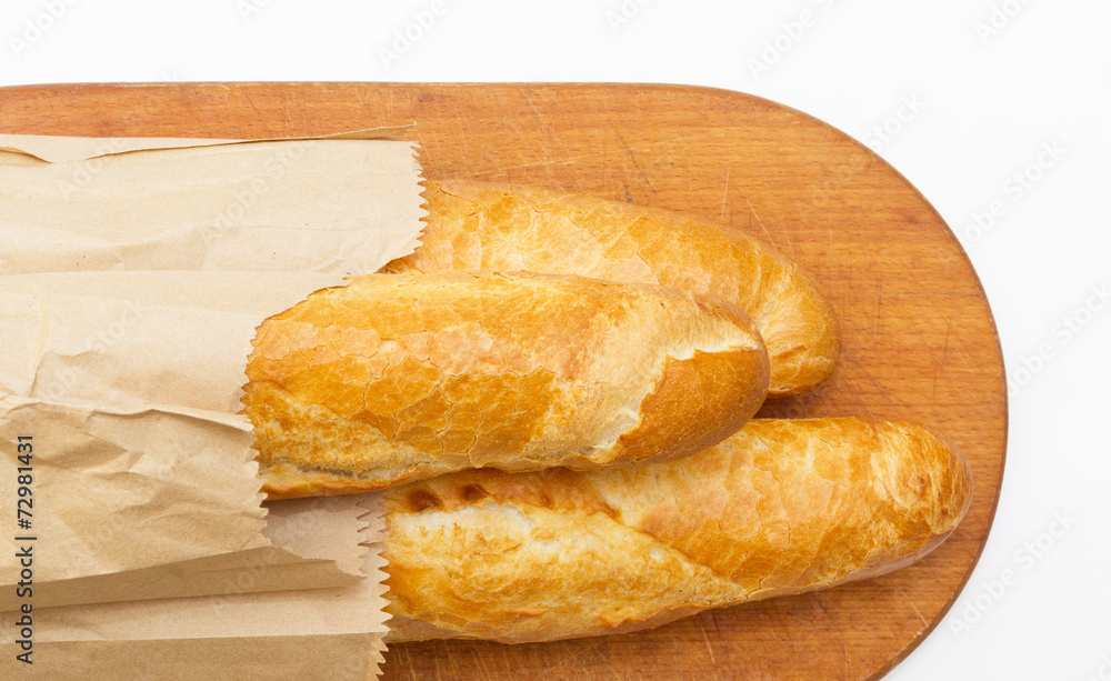 Baguettes packaged in a paper on a board on white background