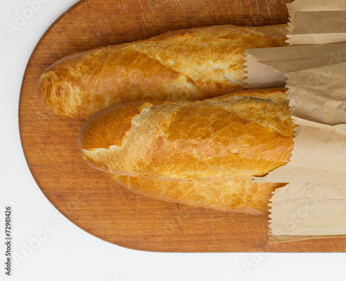 Obraz na płótnie Baguettes packaged in a paper on a board w salonie