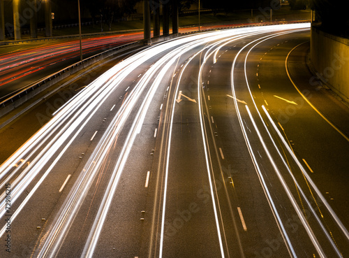 Cars traveling along a freeway at night.