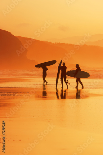 Photography surfers on the shore at sunset