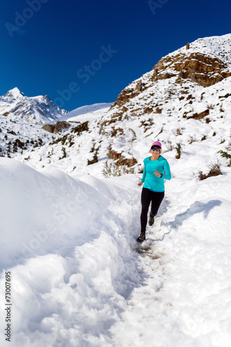 Happy woman cross country running in winter