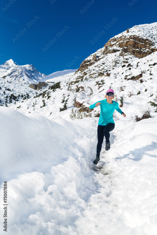 Woman happy running on snow in winter