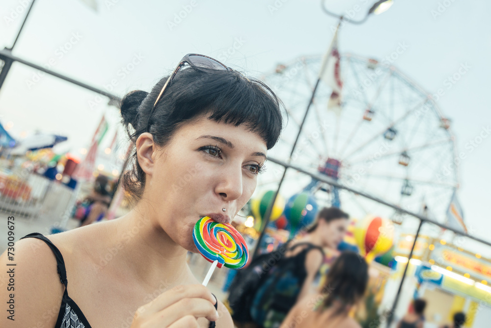 Fototapeta premium Happy Young Woman eating Lollipop