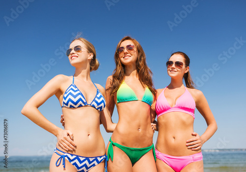 group of smiling young women on beach