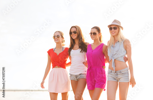 group of smiling women in sunglasses on beach © Syda Productions