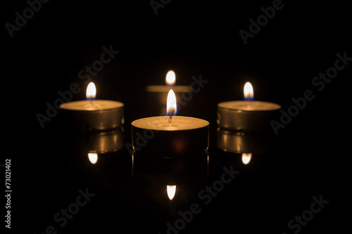 Four Tea Candles with Reflection on Black