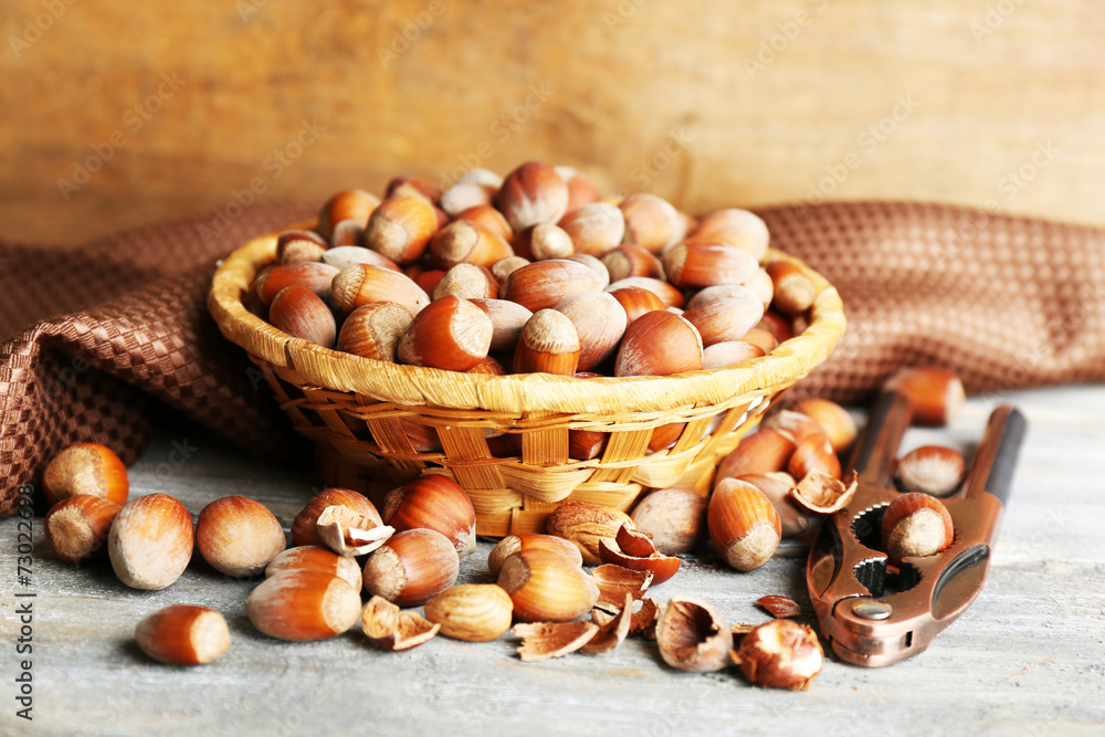 Hazelnuts in wicker basket on wooden background Hazelnuts in wicker basket on wooden background
