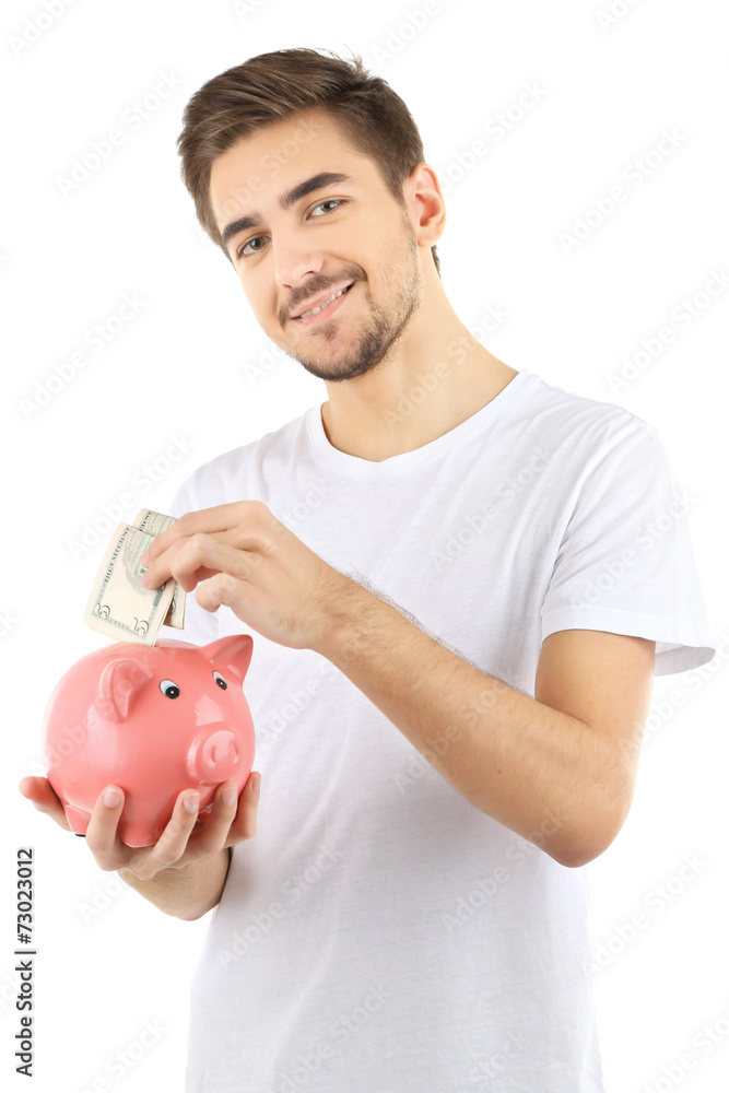 Handsome young man with piggy bank isolated on white Handsome young man with piggy bank isolated on white