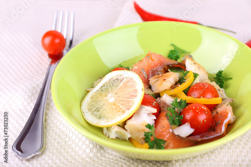 Appetizing fish salad with vegetables on plate on table
