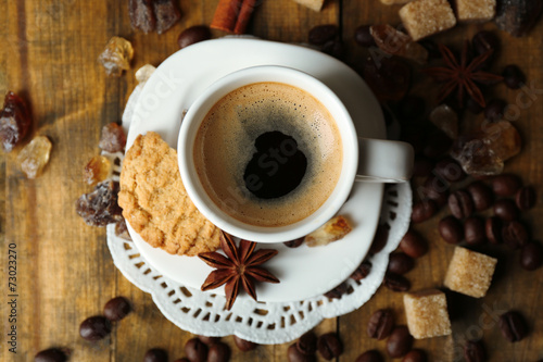 Cup of coffee and tasty cookie on wooden background