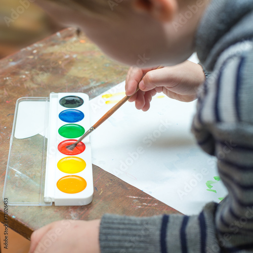 boy painting with watercolors