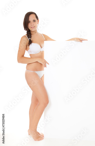 Foto Attractive girl in white underwear standing next to white sign.