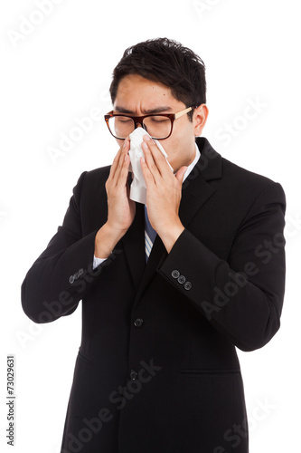 Fototapeta Naklejka Na Ścianę i Meble -  Asian businessman caught cold. Sneezing into tissue.