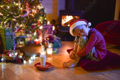 A little boy fell asleep while waiting for Santa Claus in front
