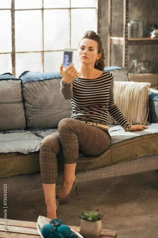 Obraz premium Young woman making selfie in loft apartment