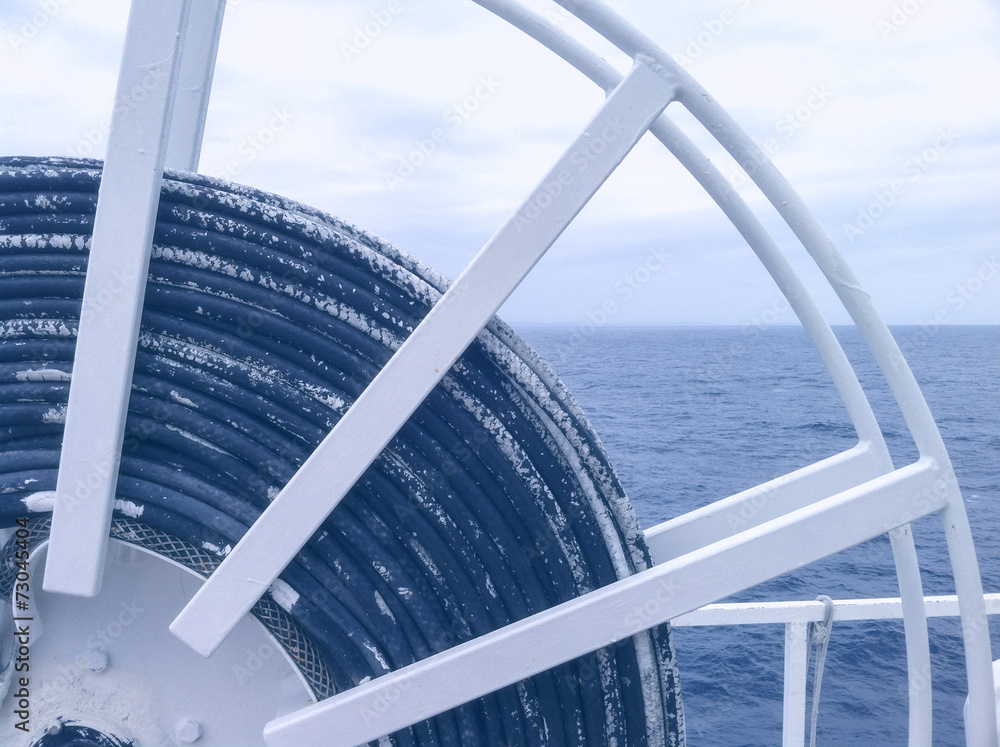Naklejka premium Ship winch with cable and ocean in the background