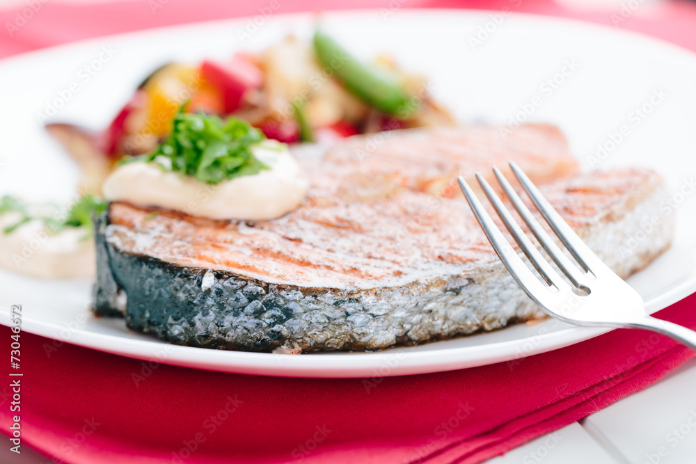Grilled Salmon with Fresh vegetables on red background