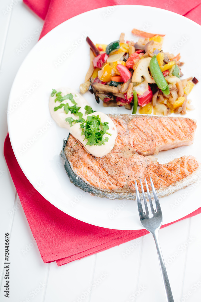 Grilled Salmon with Fresh vegetables on red background Grilled Salmon with Fresh vegetables on red background