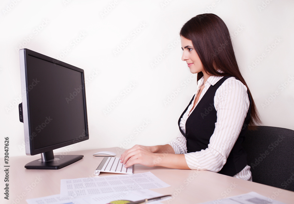 Cheerful businesswoman working at her desk looking at camera in Cheerful businesswoman working at her desk looking at camera in