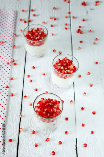 Healthy  panna cotta dessert with  pomegranate seeds in jars per photo