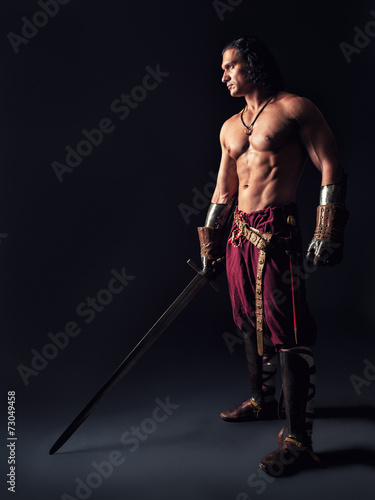 half-naked warrior with a sword in medieval clothes