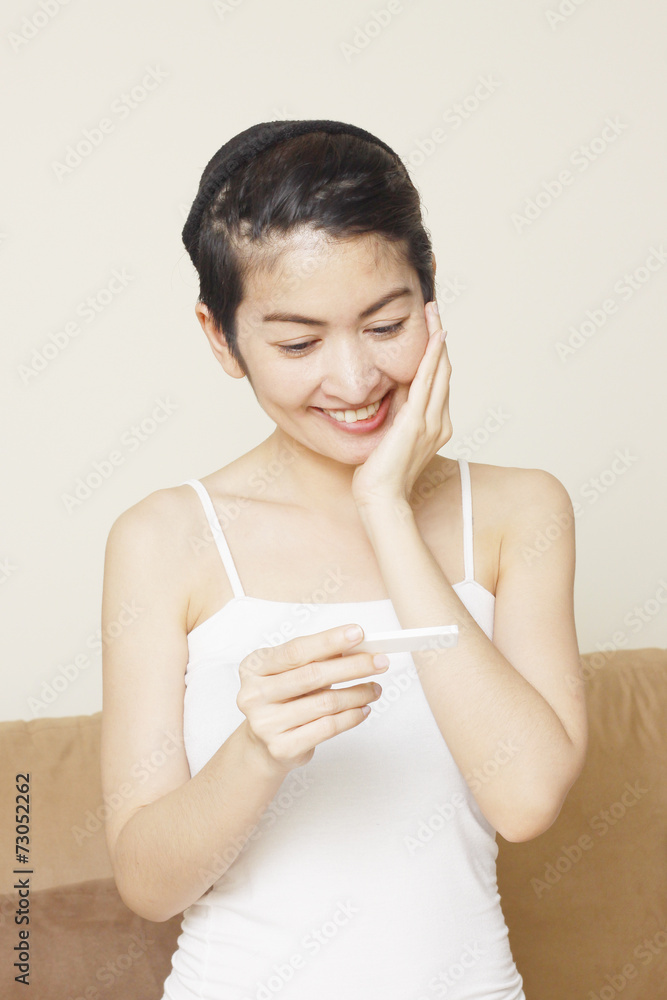 delighted young woman looking on pregnancy test delighted young woman looking on pregnancy test