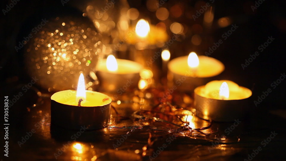 Burning small candles and Christmas tree decorations against a d Burning small candles and Christmas tree decorations against a d