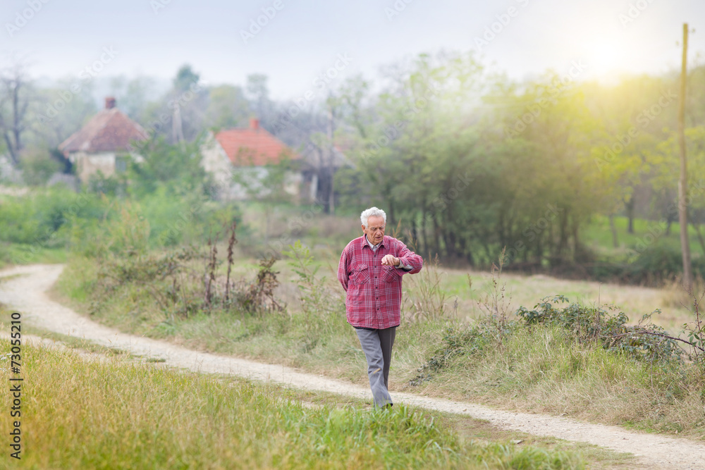 Senior man walkng in village