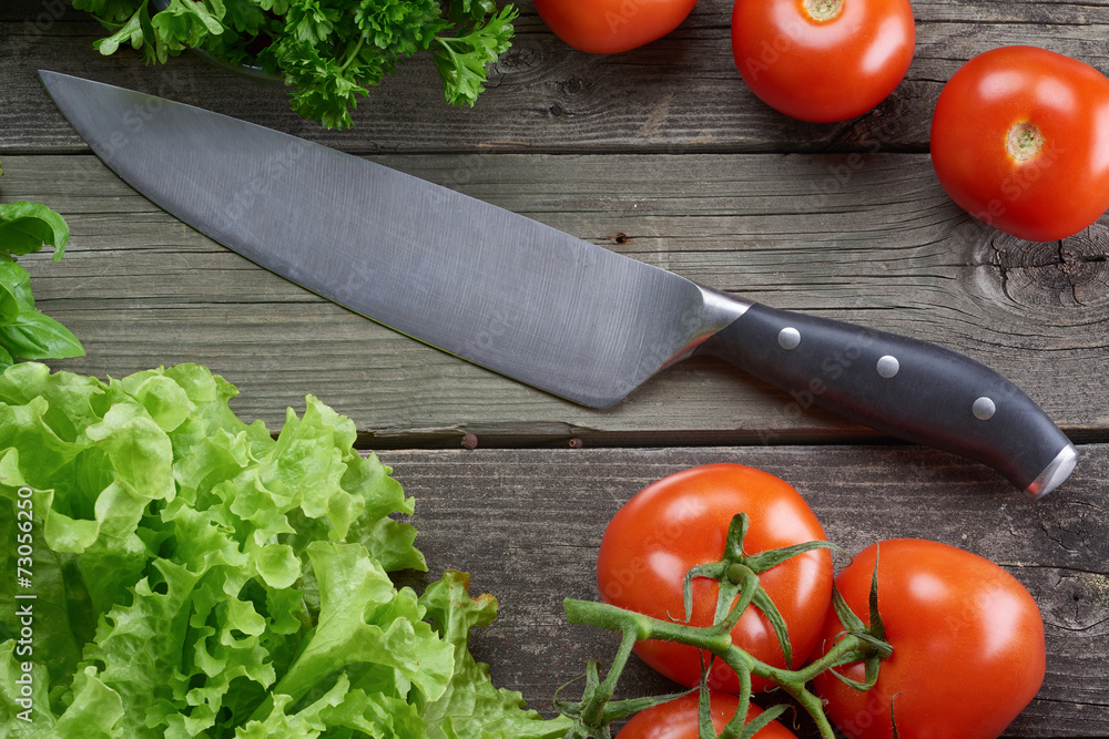 Kitchen knife in table with vegetables