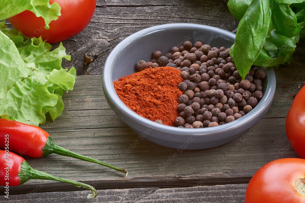Spices on old wooden table with vegetables.