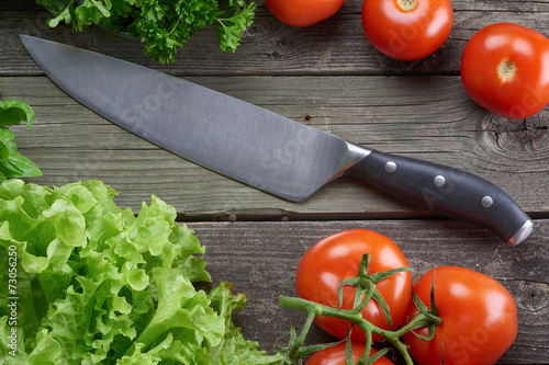 Kitchen knife in table with vegetables