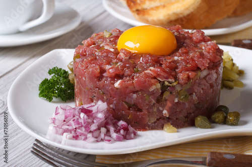 beef tartare with egg and vegetables closeup. Horizontal