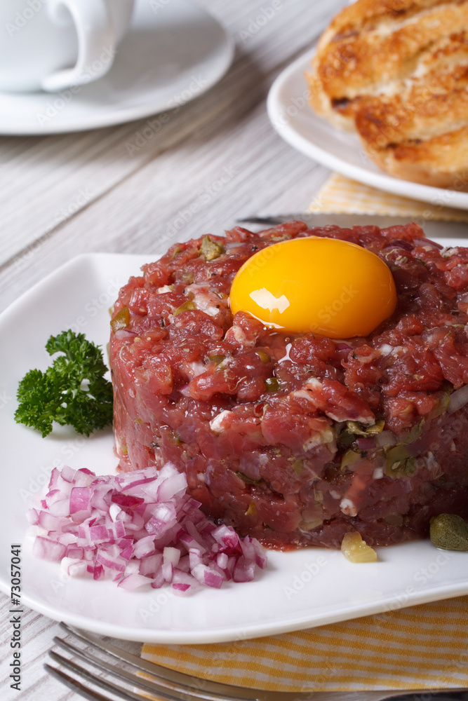 beef tartare with egg and vegetables closeup.  Vertical