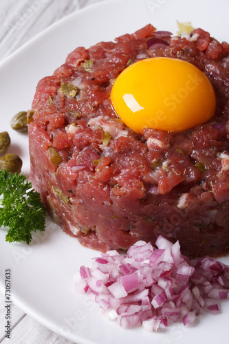 Delicious tartare of beef closeup on a white plate
