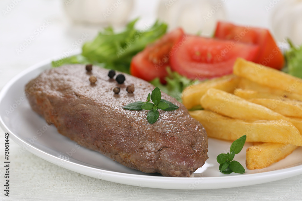 Steak Fleisch Gericht mit Pommes, Gemüse und Salat auf Teller Steak Fleisch Gericht mit Pommes, Gemüse und Salat auf Teller