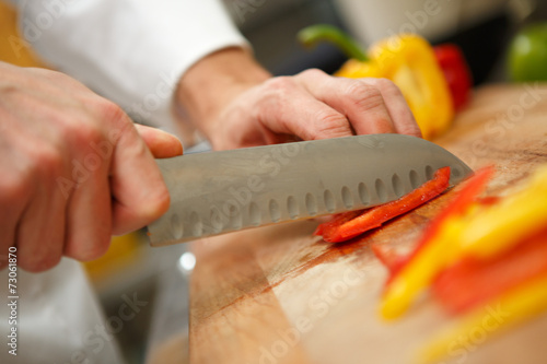 closeup on hands cutting yellow pepper
