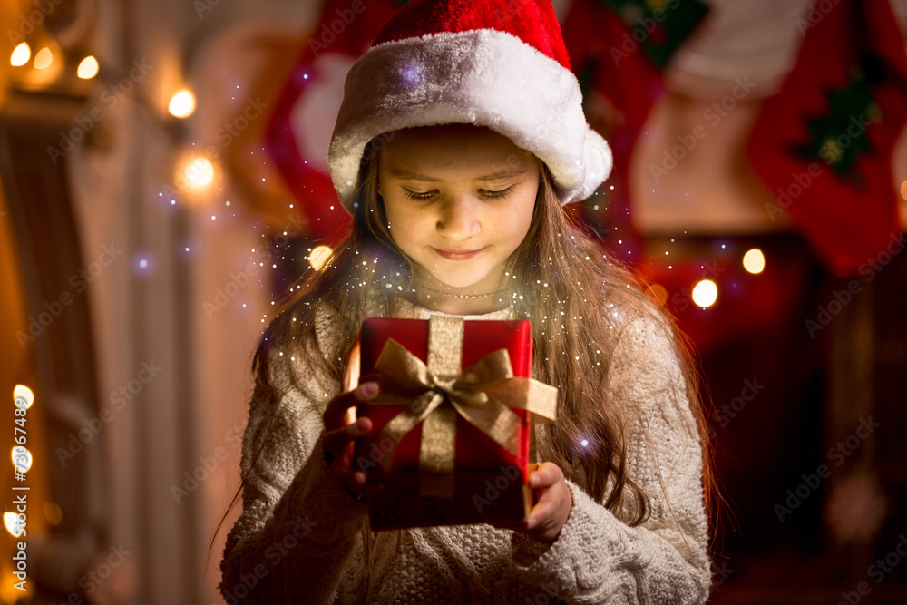 cute girl looking inside of glowing Christmas present box cute girl looking inside of glowing Christmas present box