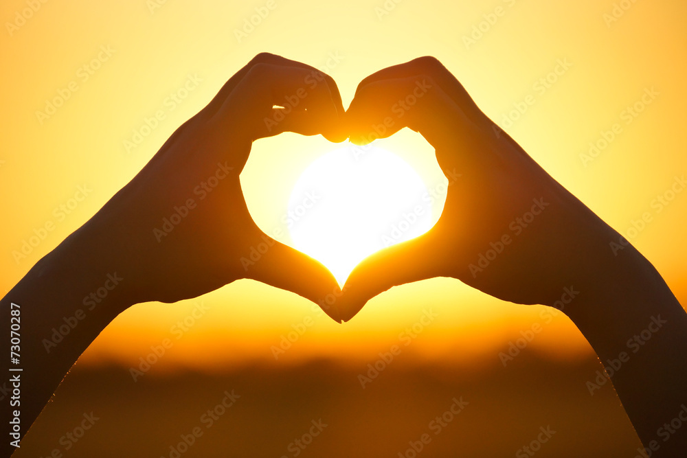 Obraz premium love shape hand silhouette at sunset