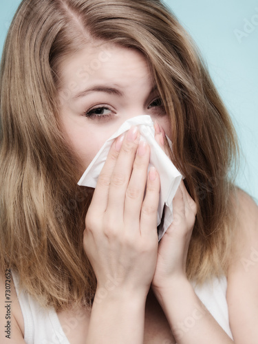 Flu allergy. Sick girl sneezing in tissue. Health