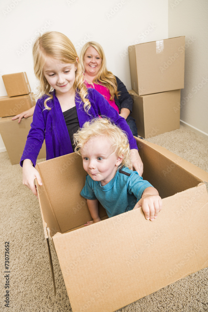 Young Family In Empty Room Playing With Moving Boxes Young Family In Empty Room Playing With Moving Boxes