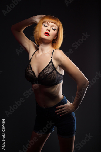 Languorous red-haired woman posing at camera