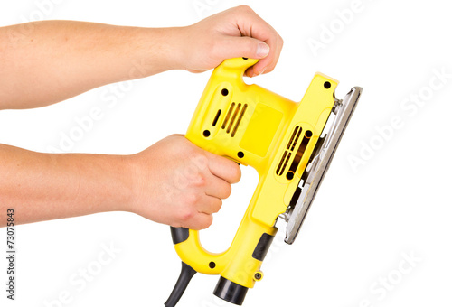 hands holding an electrical sander