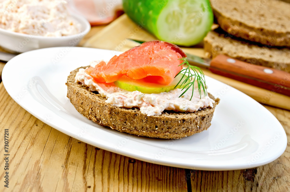 Sandwich with cream and salmon in oval plate on board Sandwich with cream and salmon in oval plate on board