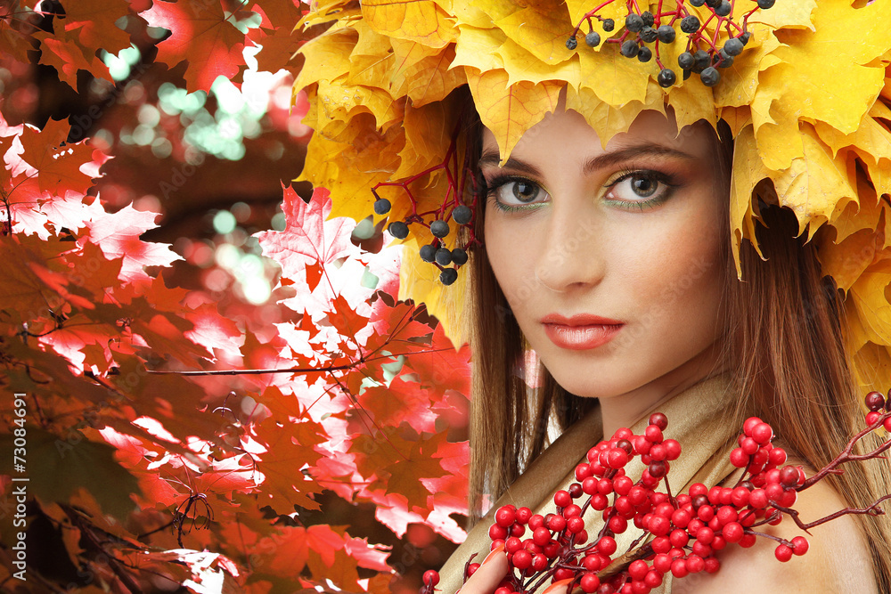 Beautiful young woman with yellow autumn wreath outdoors