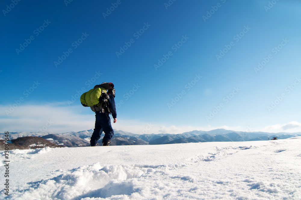 Mountaineer reaches the top of a snowy mountain.