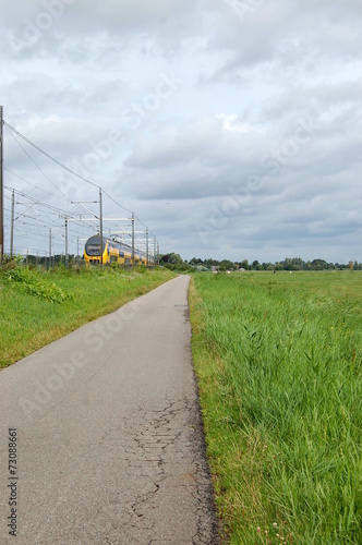 Cycle path along a train track and fields